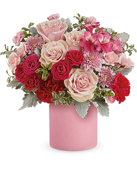 Pink roses, carnations, alstroemeria, and cushion mums with leafy accents in a frosted pink jar.