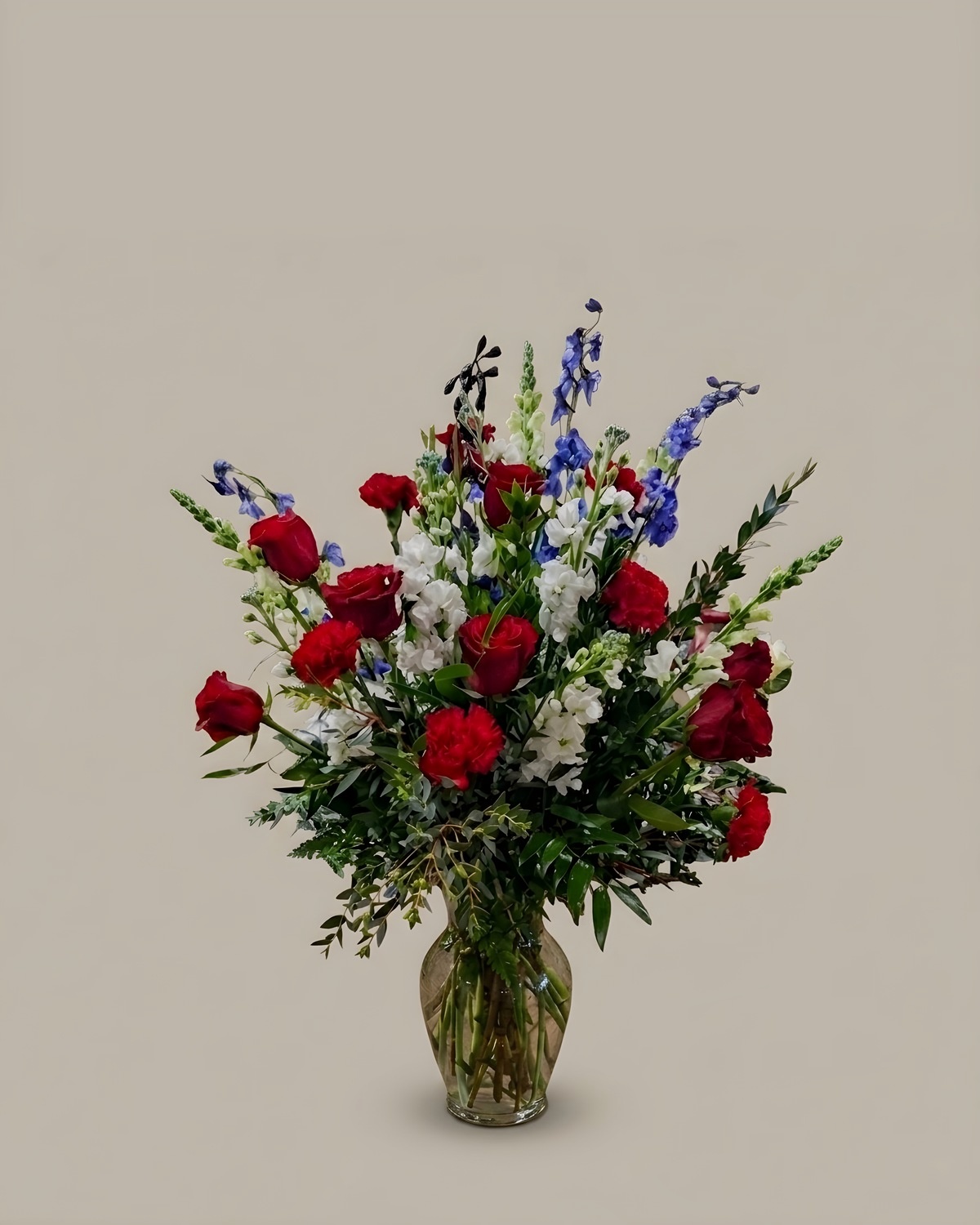Tall arrangement of red roses, blue delphinium and white snapdragon