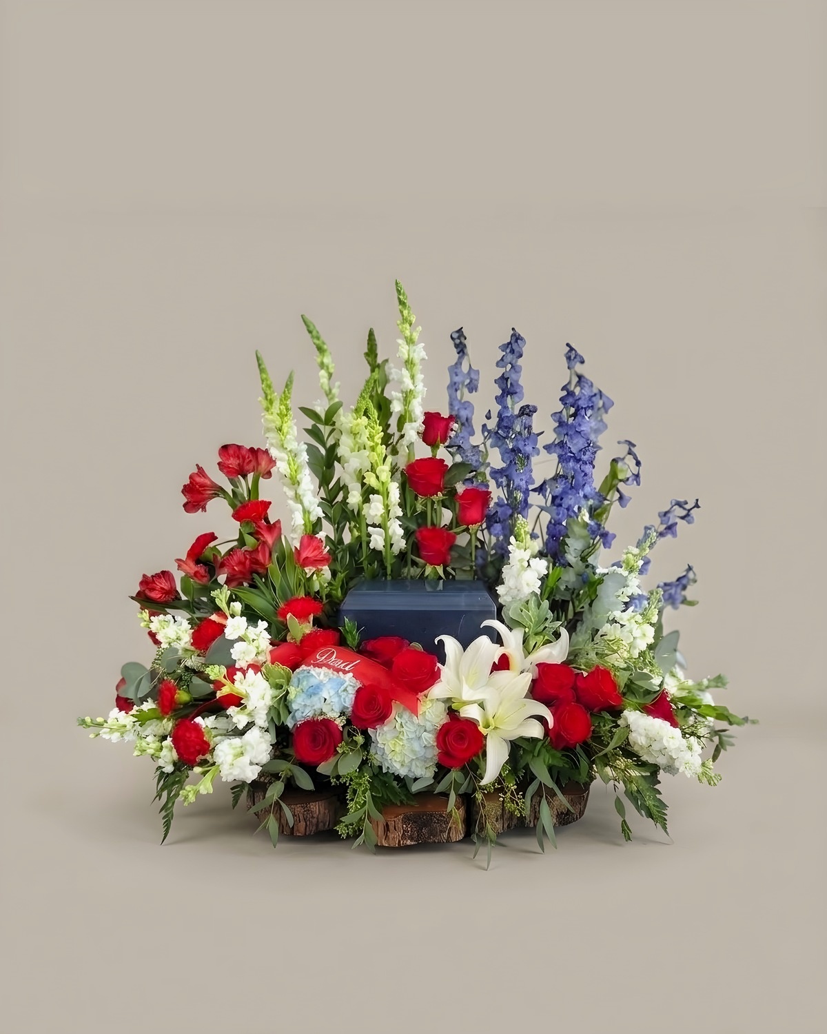 Red, white and blue urn tribute with carnations, lilies and delphinium