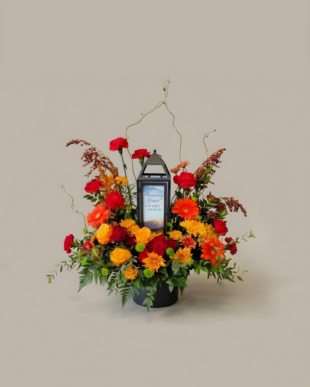 Sympathy lantern tribute in rust and orange with a black lantern at the centre